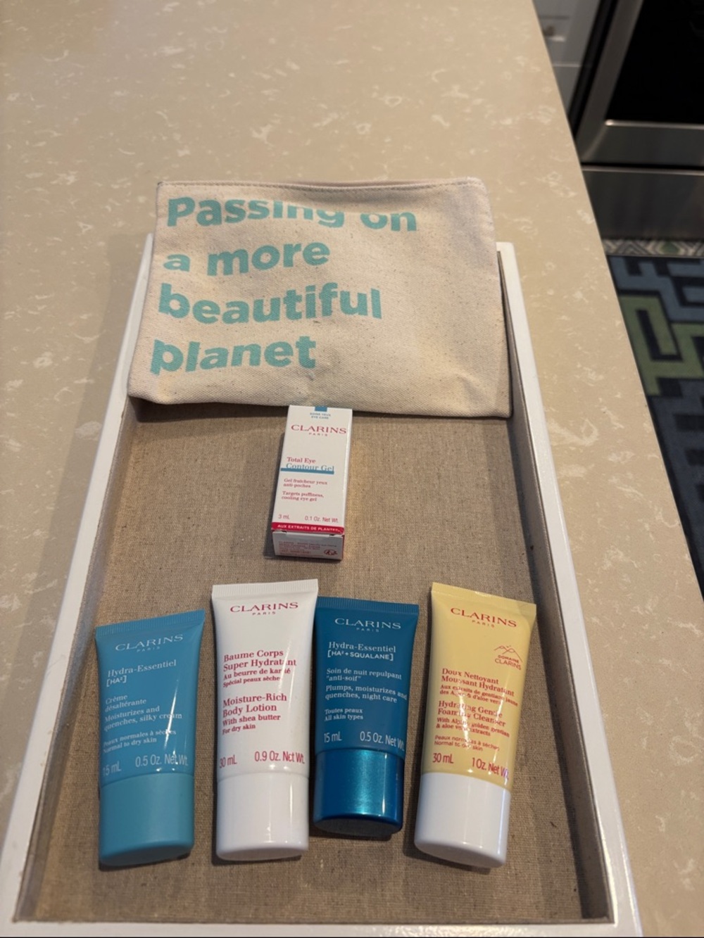 Clarins skincare set with teal, white, blue, yellow, cream pouch
